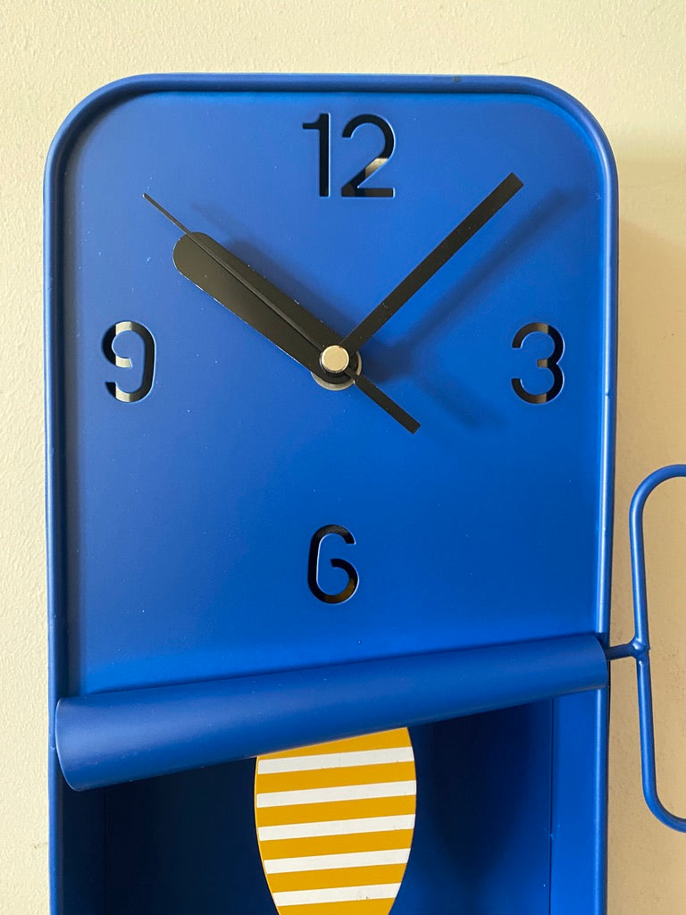 Blue wall clock with a yellow and white striped pendulum 